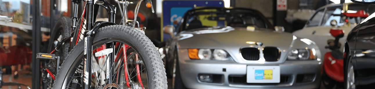 自転車の横に展示されたシルバーのBMWオープンカー